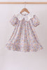Floral dress with a lace collar on a hanger against a plain background