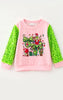 2 BOWS & CHRISTMAS CHARACTER PRINTED ON LT. PINK TOP WITH GREEN SEQUINS SLEEVES.